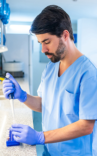 Scientist using a pipette in a lab.